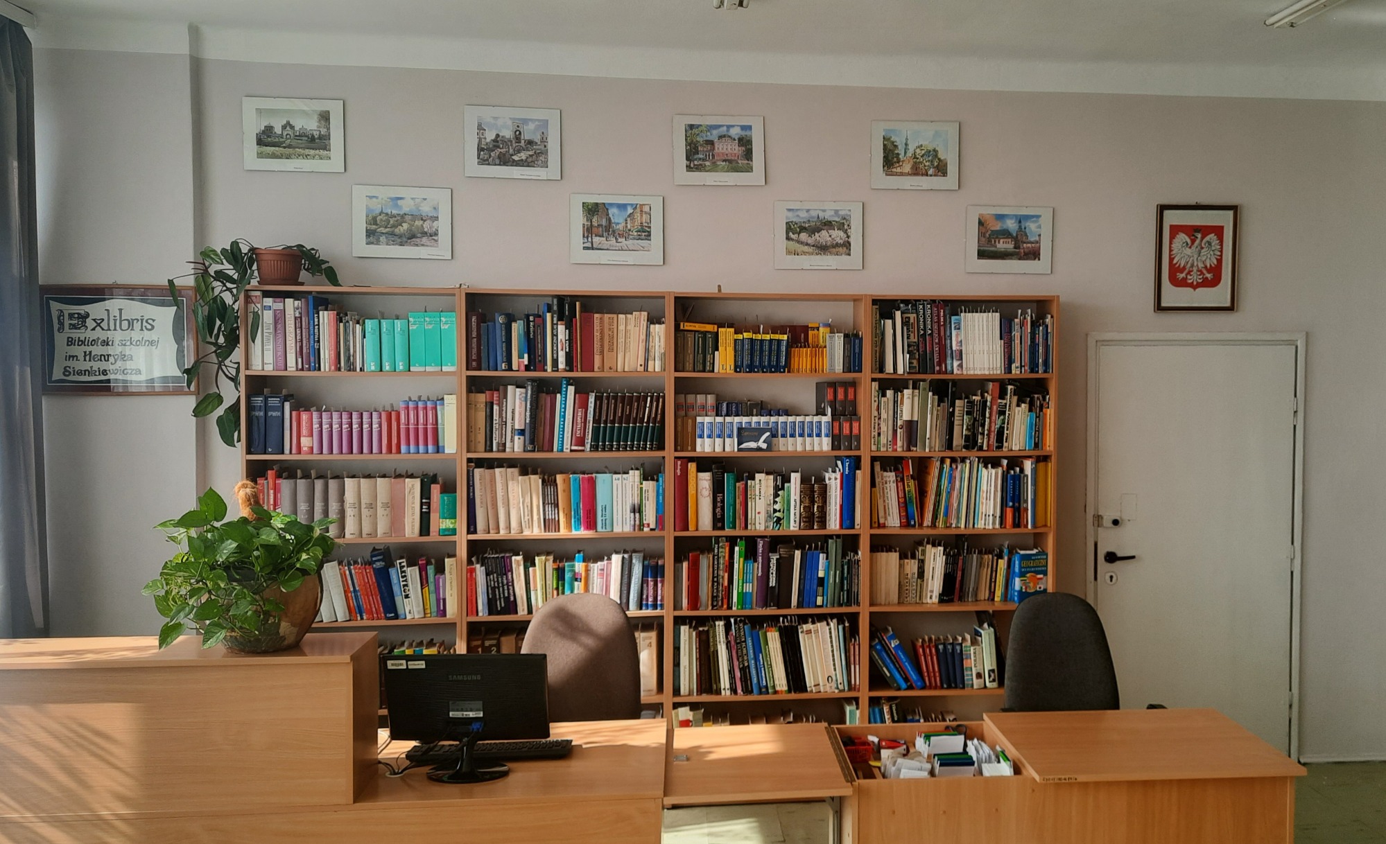 Wnętrze biblioteki szkolnej z regałami książek i stanowiskiem obsługi